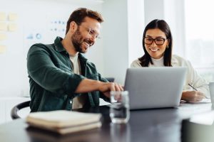 Two business people using a laptop together in an office
